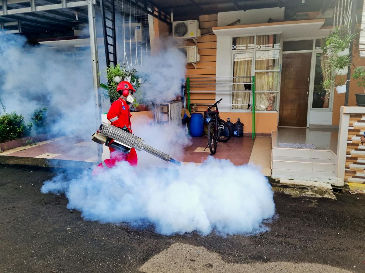 Pest control technician inspecting and treating a residential property