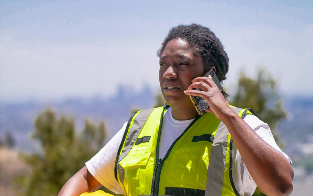 Woman in safety gear making a mobile phone call outdoors